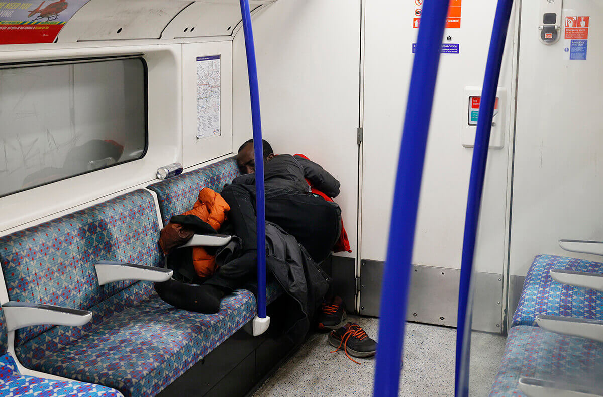 Homeless person asleep on public transport